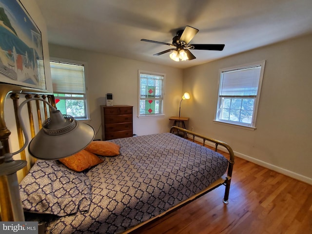 bedroom featuring wood finished floors, ceiling fan, and baseboards