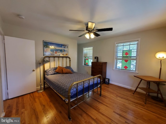 bedroom featuring wood finished floors, ceiling fan, and baseboards