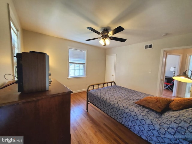 bedroom featuring baseboards, visible vents, light wood-style floors, and ceiling fan