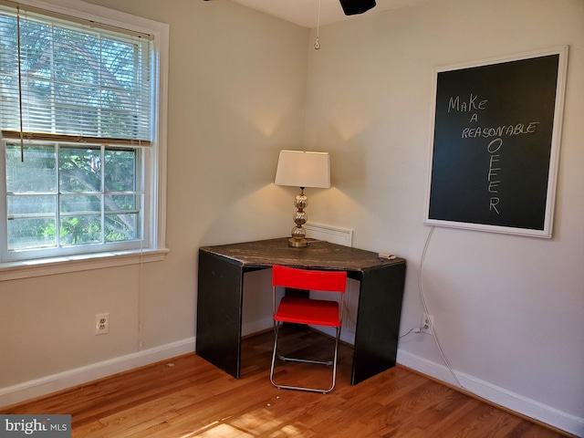 office area with a wealth of natural light, wood finished floors, and baseboards
