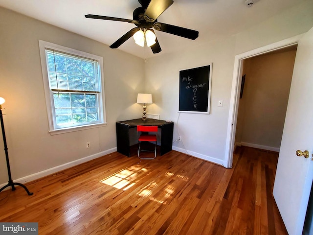 unfurnished bedroom with wood finished floors, a ceiling fan, and baseboards