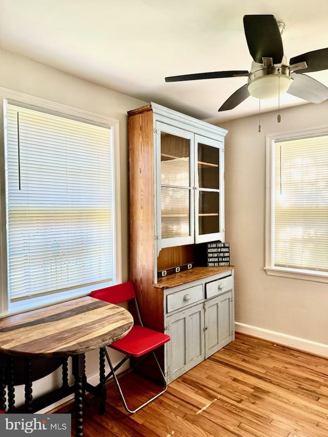 dining room featuring light wood-style floors, ceiling fan, and baseboards