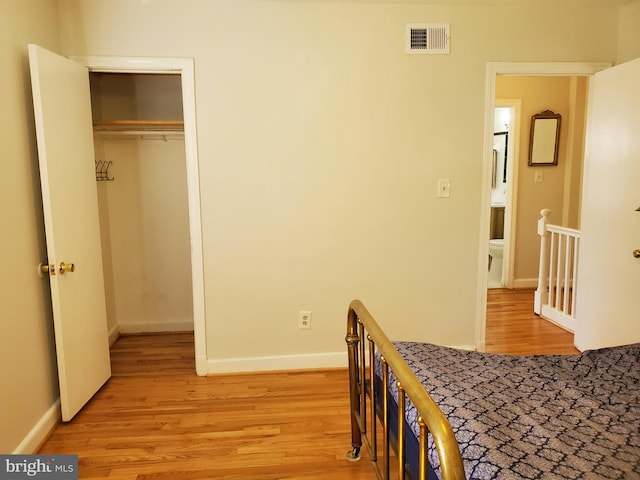 bedroom with light hardwood / wood-style floors and a closet