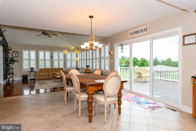 tiled dining space featuring plenty of natural light and ceiling fan with notable chandelier