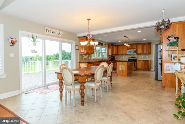 dining room with sink, a chandelier, and light tile patterned flooring