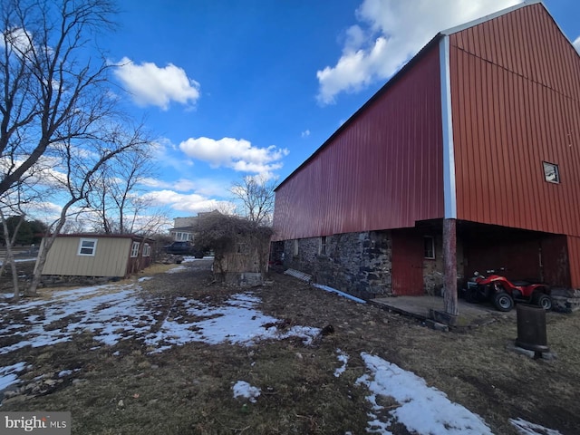 snow covered property with an outbuilding