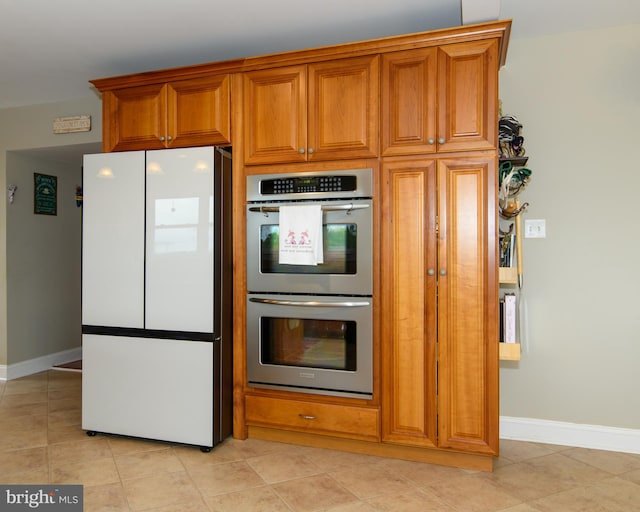 kitchen featuring light tile patterned flooring, double oven, and white fridge