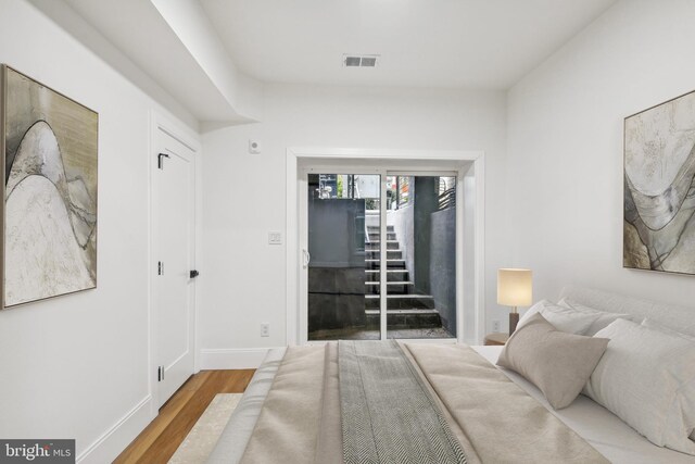 bedroom featuring access to exterior and light hardwood / wood-style floors