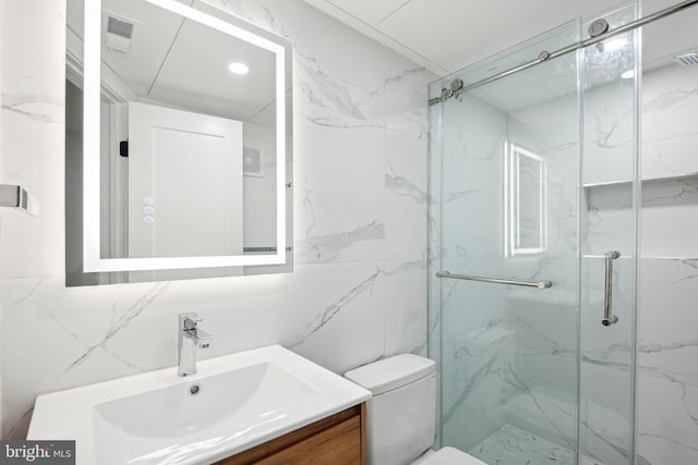 full bathroom with a marble finish shower, visible vents, toilet, and vanity