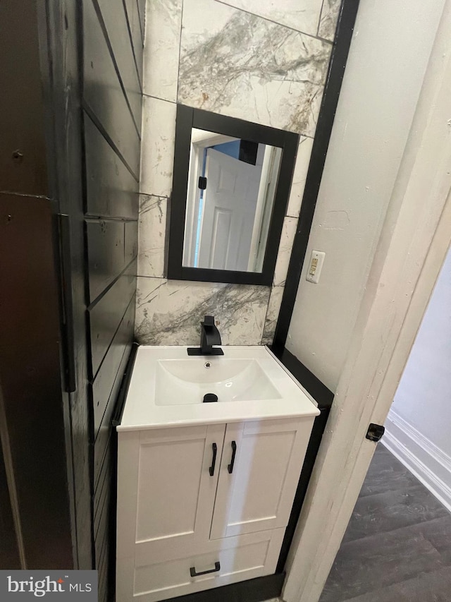 bathroom featuring decorative backsplash, vanity, and hardwood / wood-style flooring