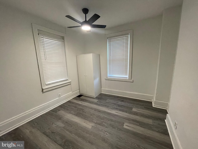 empty room with dark hardwood / wood-style floors and ceiling fan