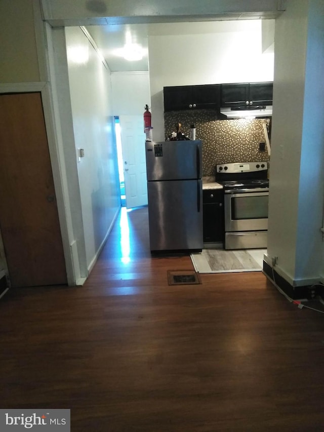 kitchen with dark hardwood / wood-style flooring, stainless steel appliances, and backsplash