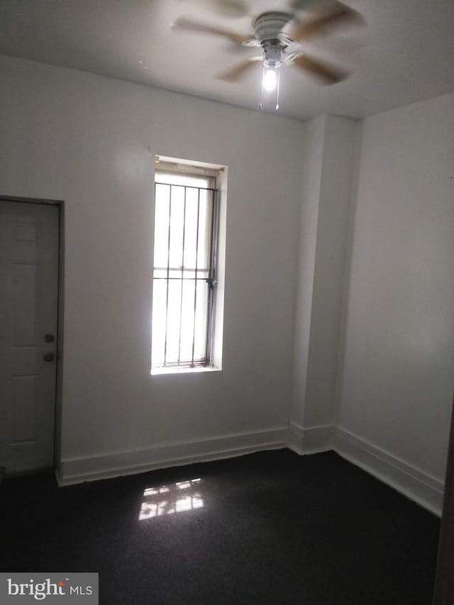 unfurnished room with ceiling fan and carpet