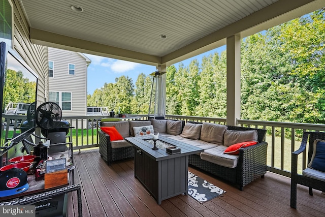 wooden terrace with an outdoor living space with a fire pit