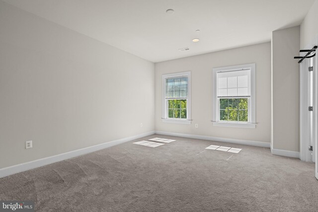 unfurnished room featuring light colored carpet