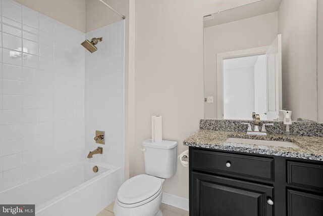 full bathroom featuring tile patterned flooring, toilet, tiled shower / bath combo, and vanity