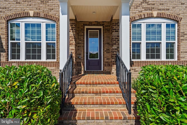 view of exterior entry with brick siding