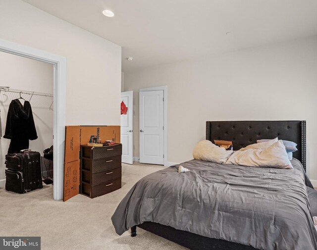 carpeted bedroom with a walk in closet and a closet