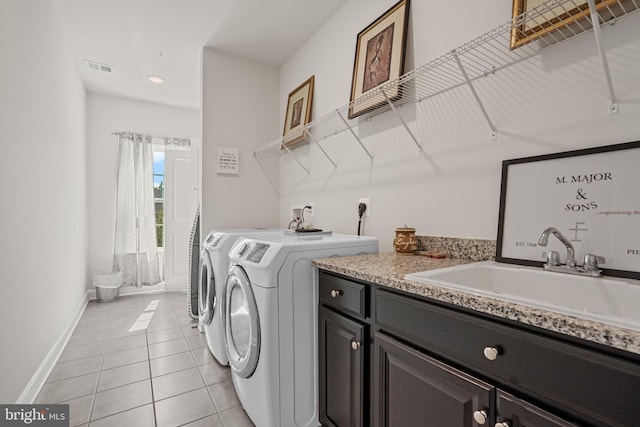 laundry room featuring light tile patterned floors, sink, cabinets, and washer and dryer