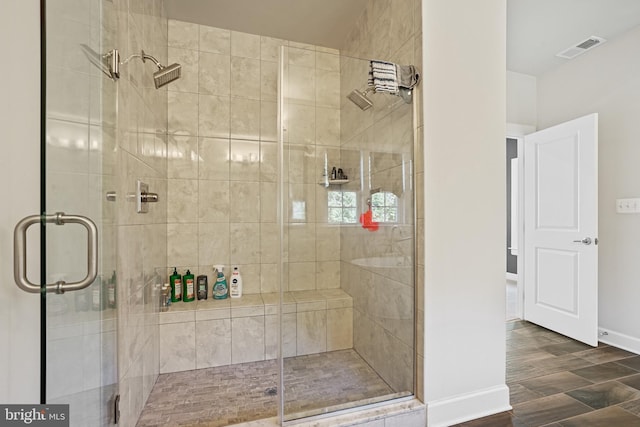 bathroom with hardwood / wood-style flooring and walk in shower