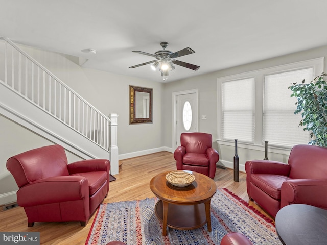 living room with light hardwood / wood-style flooring and ceiling fan