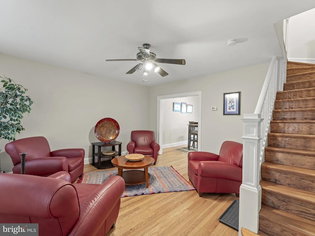 living room featuring light hardwood / wood-style flooring and ceiling fan