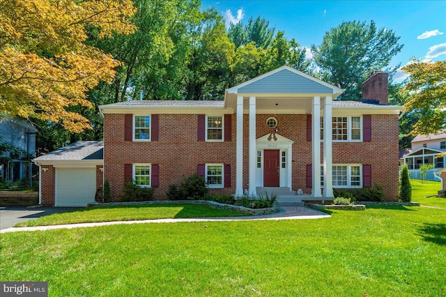 greek revival inspired property featuring a garage and a front lawn