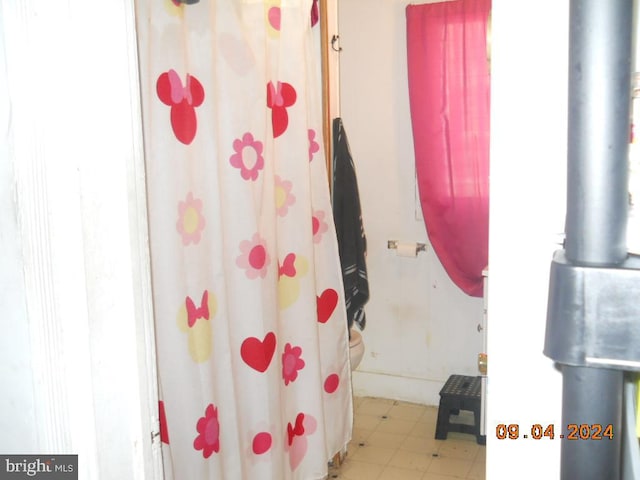 bathroom with a shower with shower curtain and toilet