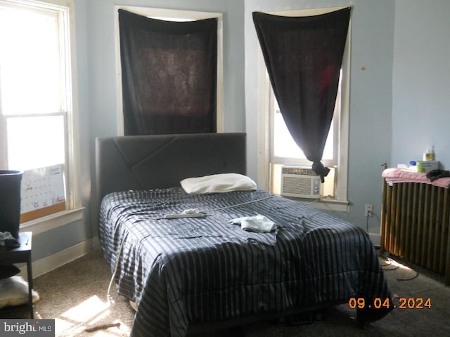 carpeted bedroom featuring cooling unit and radiator heating unit