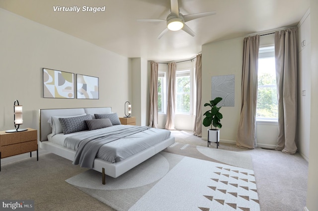 bedroom featuring light colored carpet, ceiling fan, and multiple windows