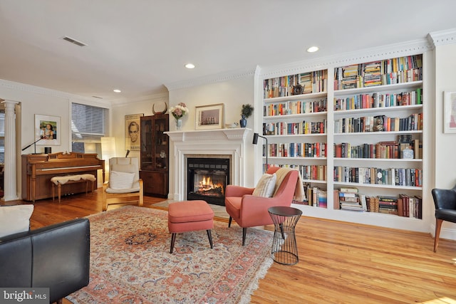 sitting room with hardwood / wood-style floors and ornamental molding