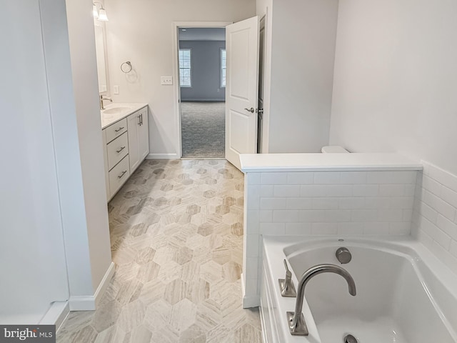 bathroom featuring vanity, a garden tub, and baseboards