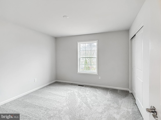 unfurnished bedroom featuring a closet, baseboards, and carpet