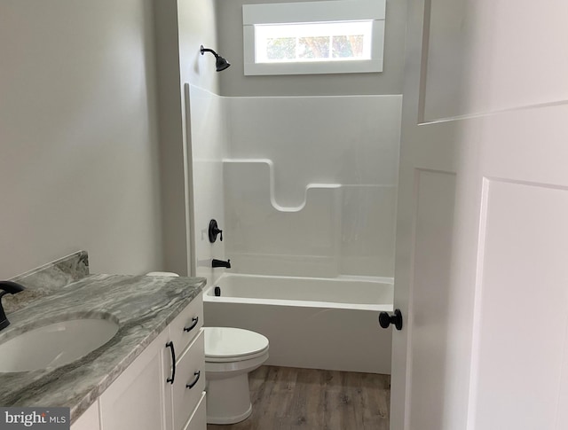 full bathroom featuring hardwood / wood-style floors, vanity, toilet, and bathtub / shower combination