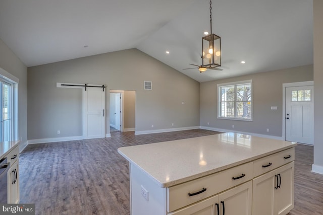 kitchen featuring a barn door, light wood-style flooring, open floor plan, and ceiling fan