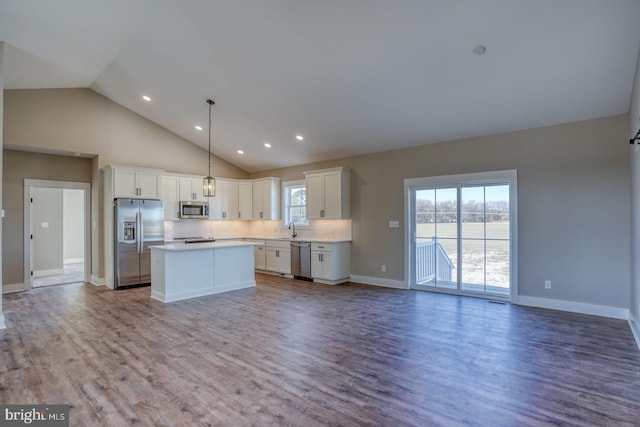 kitchen featuring open floor plan, plenty of natural light, stainless steel appliances, and a sink