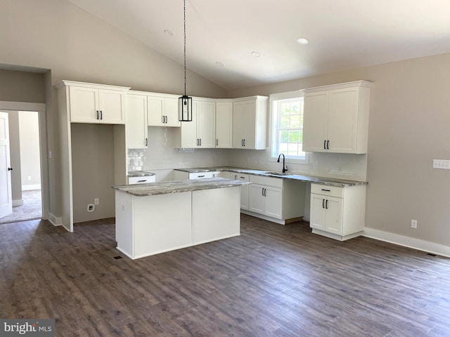 kitchen featuring white cabinets, a center island, and dark wood-type flooring