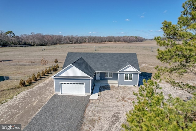 ranch-style house featuring crawl space, a rural view, gravel driveway, and roof with shingles