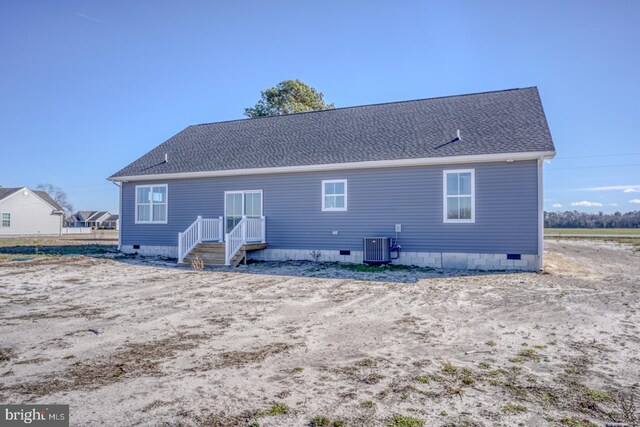 back of property with central AC unit, roof with shingles, and crawl space