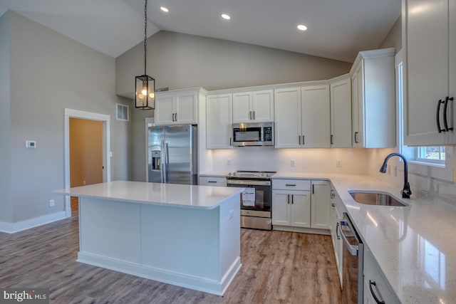 kitchen with white cabinetry, stainless steel appliances, light wood-type flooring, and a sink