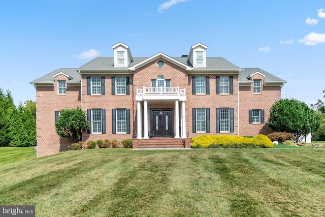 view of front of house featuring a balcony and a front lawn