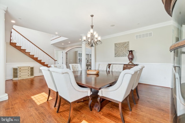 dining space with crown molding, an inviting chandelier, and hardwood / wood-style flooring