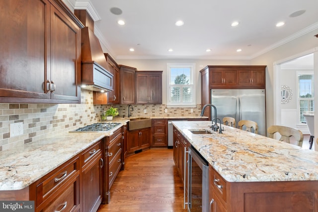 kitchen with appliances with stainless steel finishes, plenty of natural light, a center island with sink, and sink