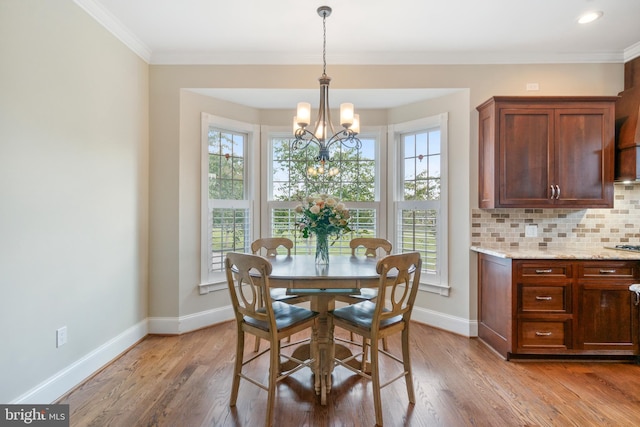 dining area featuring ornamental molding, hardwood / wood-style floors, and a chandelier