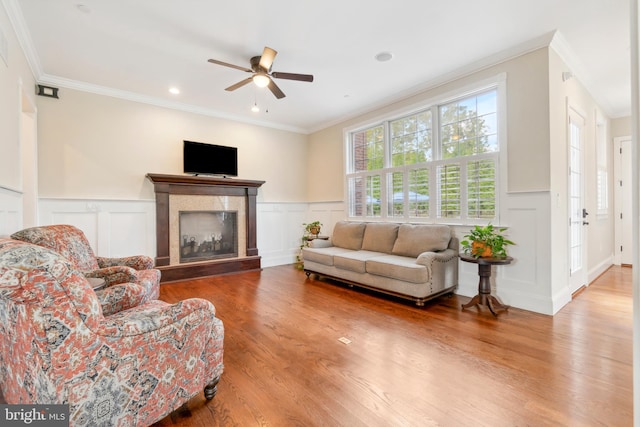 living room featuring crown molding, hardwood / wood-style floors, and ceiling fan