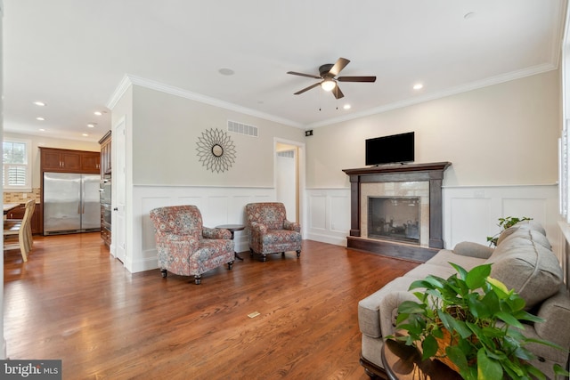 living room featuring ornamental molding, wood-type flooring, and ceiling fan