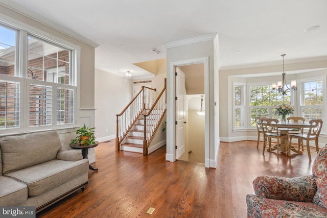 living room with hardwood / wood-style floors, a chandelier, and crown molding