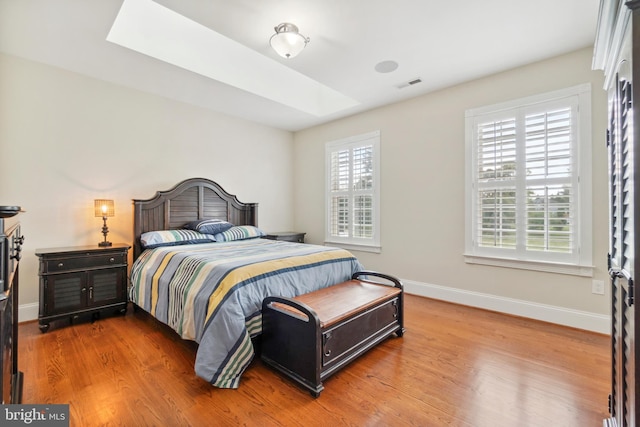 bedroom featuring hardwood / wood-style floors and multiple windows