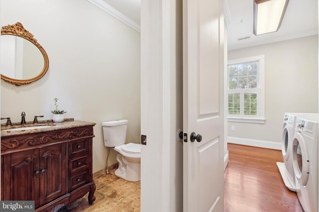 bathroom featuring toilet, hardwood / wood-style floors, separate washer and dryer, vanity, and crown molding