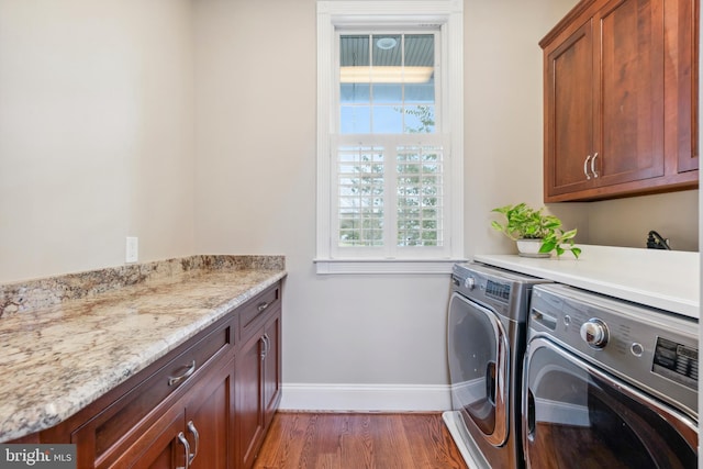 laundry room featuring dark hardwood / wood-style floors, cabinets, and washer and dryer